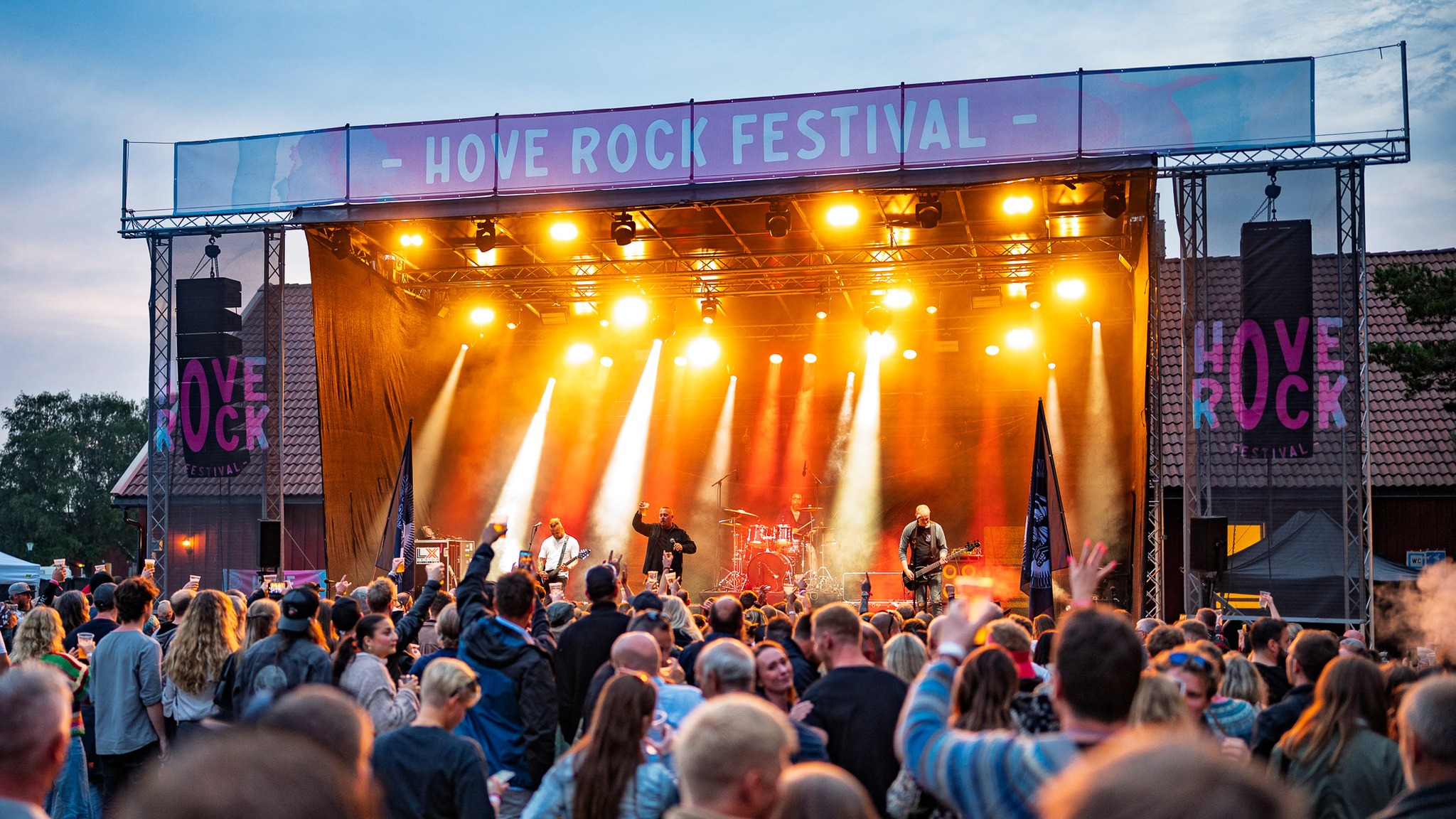 Publikum foran scenen under en norsk sommerfestival i skumringen