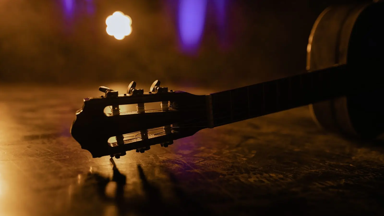 Illustrasjonsbilde: Akustisk gitarhals i varmt scenelys